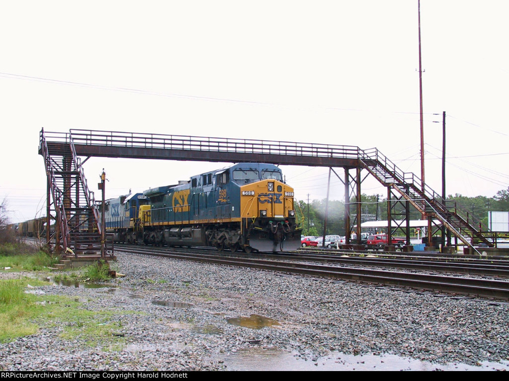 CSX 598 leads a southbound train parked under the pedestrian overpass (in a light rain)